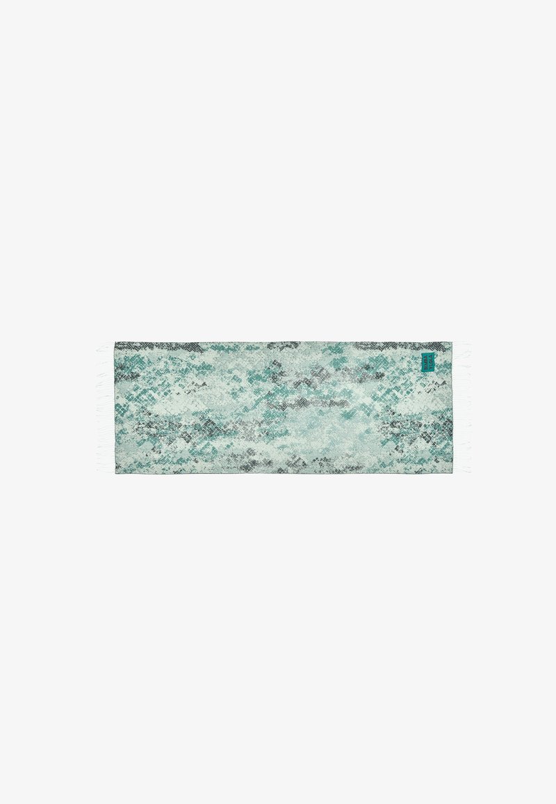 Caminito textil con un patrón multicolor en tonos azul verdoso, gris y negro, con bordes flecos. Forma rectangular, textura suave.