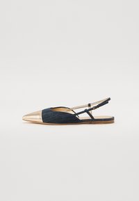 Chaussure plate en denim à bride arrière, avec un bout pointu en métal doré, présentant une tige en tissu texturé et des fines lanières.