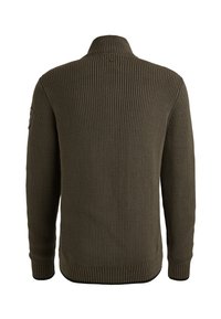 Donkergroene ribgebreide trui met hoge kraag, lange mouwen en een gestructureerde afwerking. Bevat een patch op de linkerarm voor extra detail.