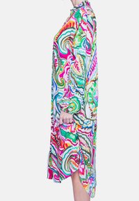 Robe colorée et imprimée en tissu léger ; elle possède des manches longues, un col et des fentes sur les côtés pour plus de liberté de mouvement.