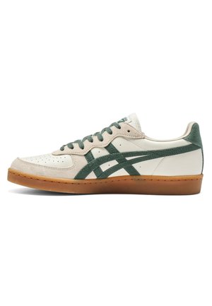 Hvid og beige lavt sneakers med grønne striber, matchende grønne snørebånd og en brun gummisål, vist fra ydersiden.