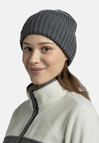 Gray ribbed knit beanie with a snug fit, paired with a lighter fleece jacket featuring a high collar and a button closure.