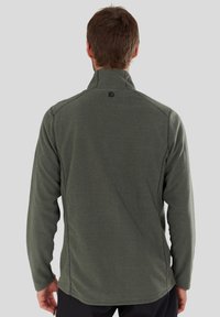 Green fleece jacket with a high collar, flat seam detailing, and a logo on the back. Soft texture, long sleeves, and a relaxed fit.