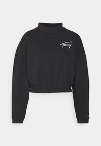 Sudadera recortada negra con cuello alto, cintura elástica y logotipo bordado en blanco. Tejido grueso con mangas largas y sueltas.