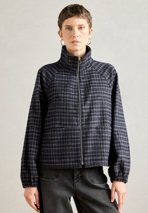 Navy rutet zip-up jakke med høj krave og elastiske manchetter, lavet af tekstureret stof. Har forlommes og et afslappet fit design.