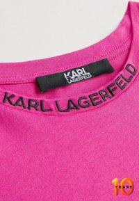 Rosa Baumwoll-T-Shirt mit einem runden Halsausschnitt und schwarzem, gesticktem "KARL LAGERFELD"-Text. Sanfte Textur ohne sichtbare Muster.
