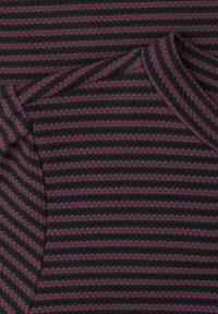 Close-up of folded knitted fabric with horizontal black and dark purple scalloped stripes.