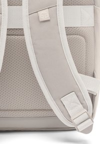 Beige hátizsák párnázott, lélegző hálós hátrésszel. Állítható pántok sima felülettel és ezüst színű részletekkel.