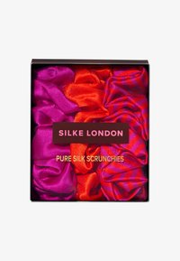 Ensemble de chouchous en soie pure aux couleurs vives : rose foncé, orange vif et un motif rayé rouge et violet. Emballé dans une boîte noire avec logo.