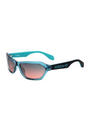Occhiali da sole sportivi con frontale blu traslucido, aste nere, lati interni blu, lenti marroni sfumate e logo Adidas sulla stanghetta.