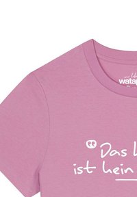 Roze katoenen t-shirt met een ronde halslijn, korte mouwen en witte tekst met de woorden "Das Leben ist kein." De textuur lijkt glad en zacht.