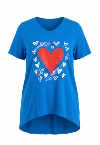 Chemise bleu à col en V avec un grand cœur rouge au centre, entouré de petits cœurs blancs et violets et d'accents de coups de pinceau.