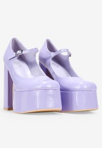 Tacchi a piattaforma in pelle verniciata viola con punta arrotondata e cinturino alla Mary Jane. Presentano un tacco quadrato spesso e una finitura liscia e lucida.