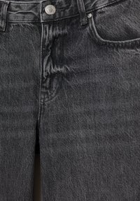Tmavosivé džínsy z denimu s jemnou textúrou, piatimi vreckami, zapínaním na kovový gombík a jemným vyblednutím pre opotrebovaný vzhľad.