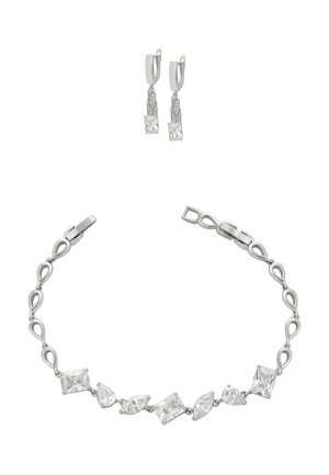 Silberfarbener Schmuckset mit einem Armband, das abwechselnd geformte klare Kristalle zeigt, und passenden Ohrhängern mit quadratischen und dreieckigen Edelsteinen.