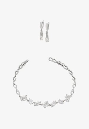Smykkesæt i sølvfarve med et armbånd, der har klart krystaller i vekslende former, og matchende drop-øreringe med firkantede og trekantede ædelsten.