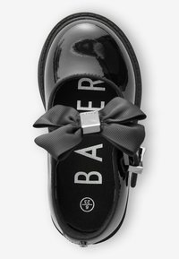 Schwarze Lackleder-Ballerinas mit einem strukturierten schwarzen Schleifen-Design und silbernem Akzent. Sie verfügen über ein Innenfutter mit weißer Markenbeschriftung.