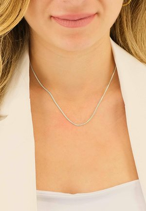 Silberne Halskette mit zartem, flachem Design, das eine glatte, reflektierende Oberfläche und ein dezentes Kettenmuster aufweist, liegt auf unbedeckter Haut.