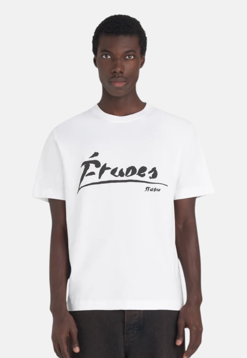 T-shirt court à manches courtes en coton. Présente un grand logo graphique « Études » en noir sur le devant. Col rond, coupe décontractée.