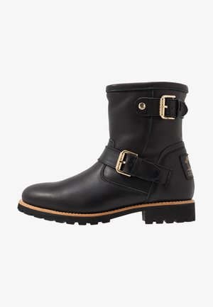 Stivale alla caviglia in pelle nera con dettagli in fibbia, punta tonda, suola testurizzata e dettagli in hardware dorato. Design robusto con tacco basso.
