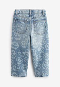 Jean en denim bleu clair avec un motif de crânes répété. Comprend deux poches arrière et un ourlet retroussé. Style classique à cinq poches avec passants de ceinture.