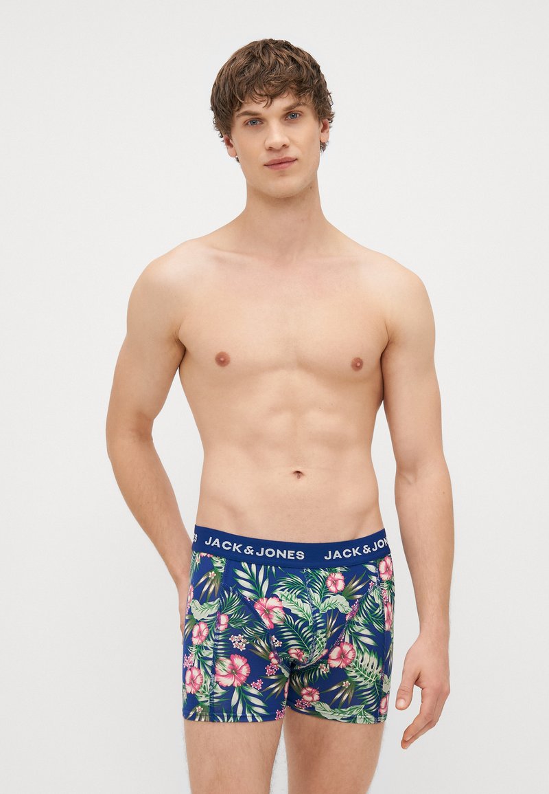 Tengerész kék boxer alsónadrág trópusi virágmintával zöld és rózsaszín színekben, kék elasztikus derékrésszel, amelyen a "JACK & JONES" felirat szerepel.
