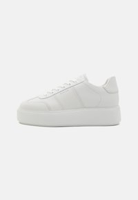 Hvit plattform joggesko med glatt skinnoppe, minimalistisk design, rund tå, og perforerte detaljer på sidene og tungen.