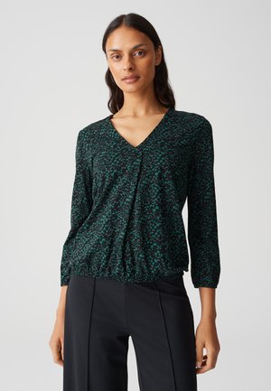 Zwarte blouse met een V-hals, met een groen abstract patroon. Driekwart mouwen en een gathered taille-detail, gemaakt van lichtgewicht stof.