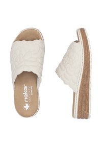 Sandales blanches à semelle plate avec un dessus texturé floral, semelle intérieure rembourrée et une semelle en liège. Présente le logo de la marque à l'intérieur.