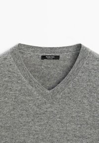 Grauer Wollpullover mit V-Ausschnitt, geripptem Kragen und Massimo Dutti Etikett, das innen am Kragen eingenäht ist.