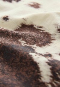 Tissu en coton présentant un motif abstrait crème et marron avec une texture douce, mettant en valeur des nuances variées de marron et un tombé fluide.