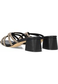 Zwarte blokhak sandalen hebben meerdere crisscross banden versierd met rhinestones. Gladde textuur met een platte zool voor stabiliteit.