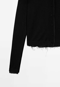 Cardigan noir à manches longues avec boutons, bords effilochés à l'ourlet et aux poignets, présenté sur fond blanc.
