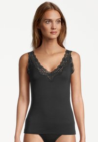Black tank top with lace trim on shoulders and neckline. Smooth fabric, fitted design, and deep V shape enhance silhouette.