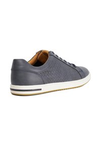 Dark gray leather sneaker with woven texture, white rubber sole, and brown interior lining. Features laces and minimal design accents.