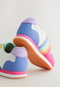 Krāsainas sporta kurpes ar ziliem, baltiem un rozā materiāliem, teksturētu augšdaļu, kontrastējošu zolīti un horizontālām svītrām pasteļtoņos.