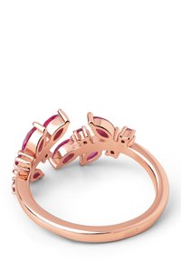 Anillo de oro rosa con piedras preciosas pink en un diseño floral, mostrando un acabado pulido suave y elementos de calado.