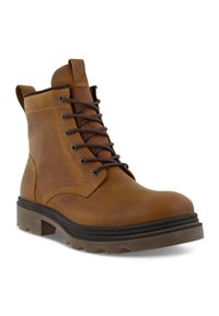 Ruskea nahkainen nilkkabootsi, jossa on pyöreä varvas, nauhakujaus, ompelutiedot ja kestävä kumipohja. Varustettu vetoketjulla helppoa pukeutumista varten.