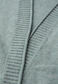 Hellblauer Cardigan mit gerippten Kanten, aus weichem Strickstoff gefertigt. Verfügt über ein V-Ausschnitt-Design und eine strukturierte Oberfläche.