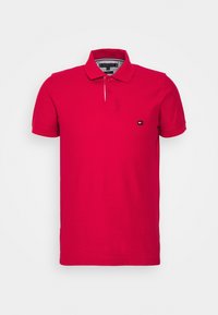 Polo en coton rouge à manches courtes, avec un col classique et un petit logo sur la poitrine gauche. Caractérisé par un ourlet droit et un minimum de détails.