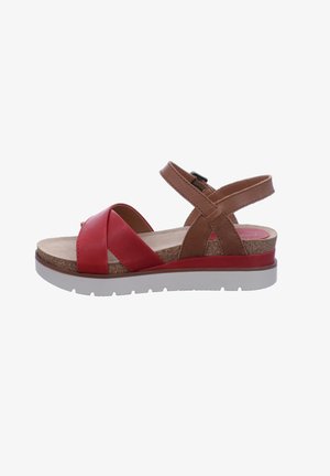 Red and brown sandal with a cork insole, cross-strap design, adjustable ankle buckle, and a white rubber sole.