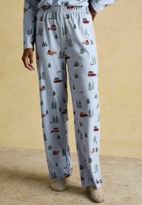 Svetlomodré pyžamové nohavice s motívom červených a žltých nákladiakov, zelených stromov a hravých detailov. Vyrobené z mäkkej látky s voľným strihom.