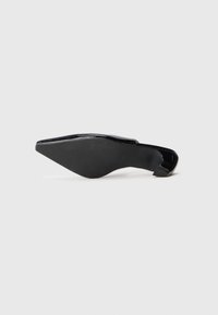 Chaussure à talon aigu en cuir verni noir avec un bout pointu et un talon fin, présentant une surface lisse et une légère texture sur la semelle.