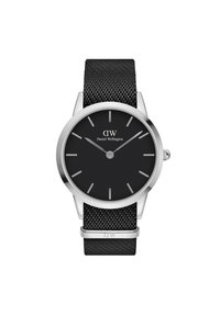 Must mustriba kell, millel on ümara kujuga roostevabast terasest korpus, must hind, hõbedased tunni markerid ja brändi nimi "Daniel Wellington".