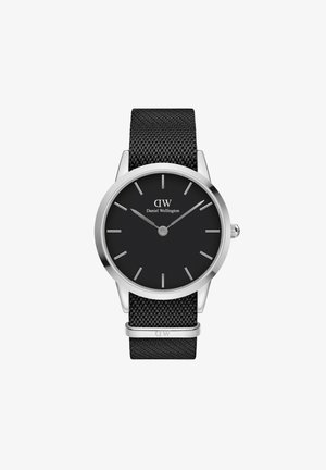 Reloj con correa de malla negra que presenta una caja redonda de acero inoxidable, esfera negra, marcadores de horas plateados y el nombre de la marca "Daniel Wellington" mostrado.