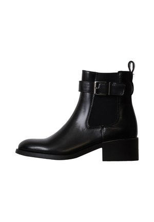 Bottine en cuir noir avec petit talon bloc, panneau élastique latéral et bride décorative avec boucle autour de la cheville.