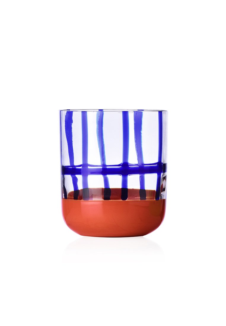 Przezroczysty szklany kubek z niebieskim paskowanym wzorem na górnej połowie i jednolitą pomarańczowo-czerwoną podstawą. Gładka struktura o zaokrąglonym kształcie.