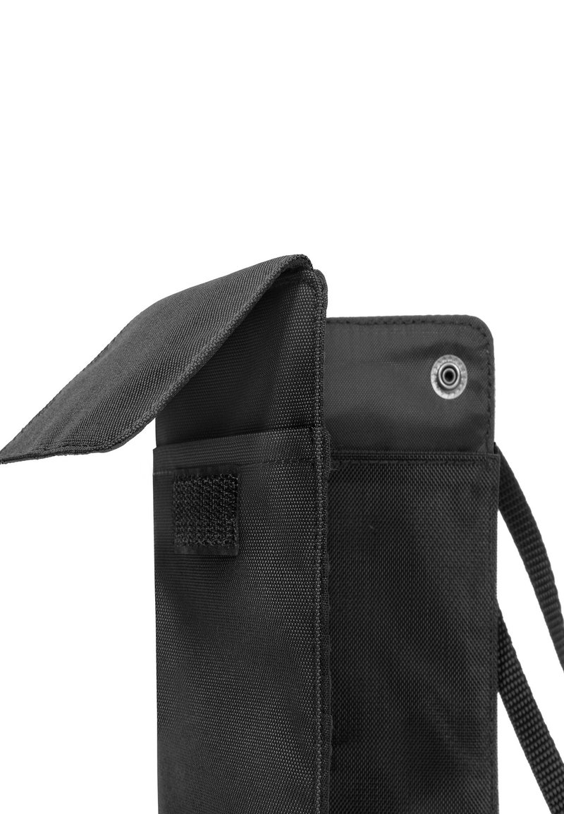 Pochette en tissu noir avec une fermeture à rabat, un patch Velcro et un œillet. La texture de surface est lisse et durable, conçue pour le stockage d'accessoires.