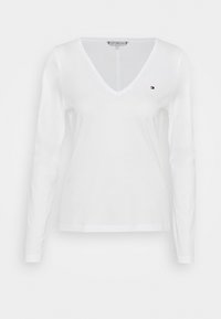Witte langemouwen V-hals shirt van katoen. Bevat een klein logo op de borst en heeft een soepele textuur. Eenvoudig en klassiek ontwerp.