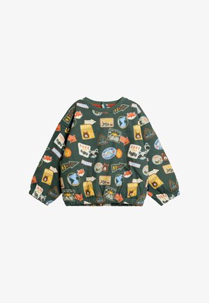 Grüner Pullover mit einem vielfältigen Muster aus Campingabzeichen, Tieren und Naturelementen. Elastischer Saum und lockere Ärmel. Aus Baumwollmaterial.